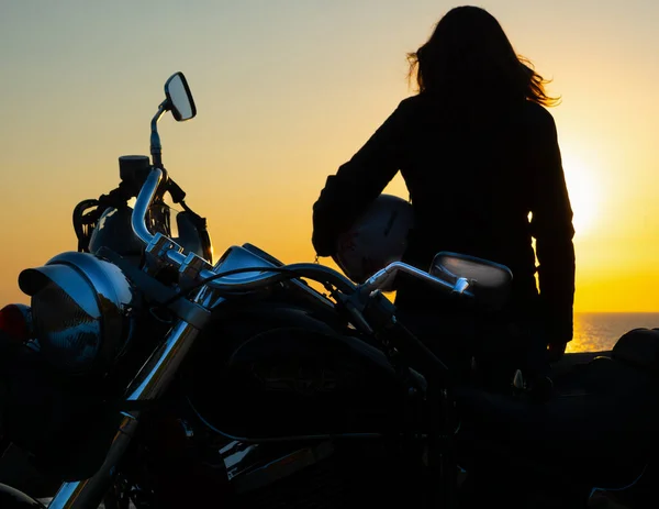 日落时在海边的女孩和摩托车的近景 — 图库照片