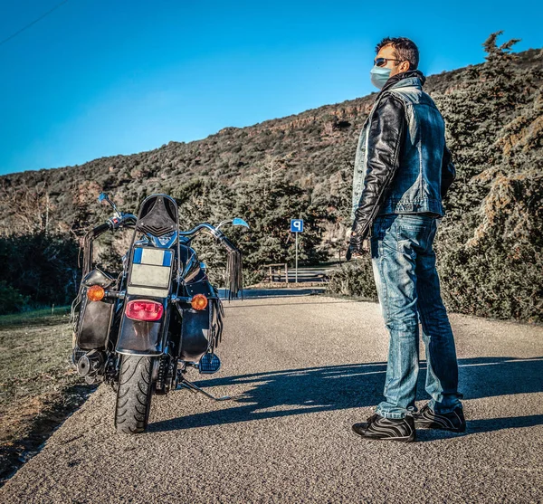 Motocyklista Maską Antywirusową Klasycznym Motocyklem Wiejskiej Drodze Zachodzie Słońca — Zdjęcie stockowe