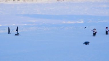 Kış, yetişkinler ve çocuklar bir kar tepe üzerinde