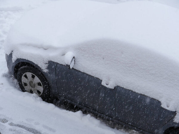 snowfall, passenger car covered with a thick layer of snow