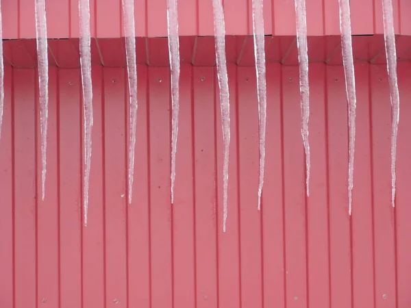 红墙上的长冰柱 — 图库照片