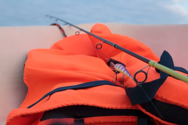 Canne à pêche sur la pêche et gilet de sauvetage orange — Photo