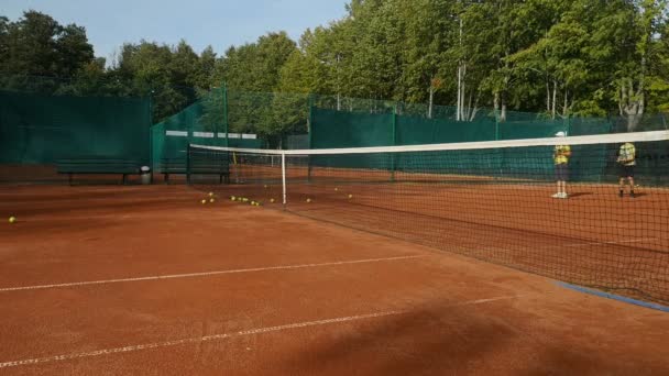 Молодые Теннисисты Тренируются Красном Теннисном Корте Теннисная Сетка Переднем Плане — стоковое видео