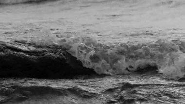 Sahildeki kayalıklarda dalgalar kopuyor.