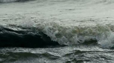 Sert deniz manzarası dalgaları kayalara çarpar.