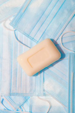 Koronavirüs ve diğer enfeksiyonlara karşı korunmak için tıbbi maskeler ve bir kalıp sabun.