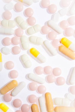 Tıbbi, eczane temalı arka plan konsepti. Beyaz arka planda beyaz ve çok renkli haplar