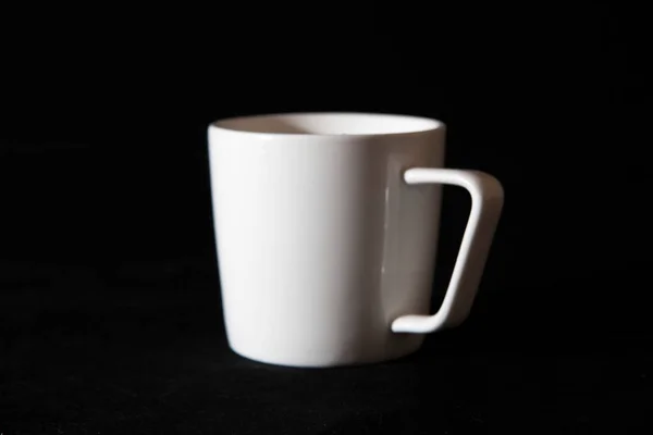 空の白いカップを反転 黒の背景 マクロ写真 — ストック写真