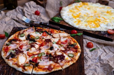  İki pizza. Birinde üç çeşit domates sosu var. Diğeri bol peynirli.. 