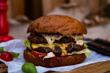 İki sığır pirzolası, altın peynir ve beyaz katran soslu sığır etli burger. Arkaplanlı fotoğraf. 