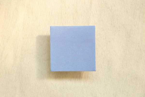 Blue memo pad, sticky note on fabric texture background