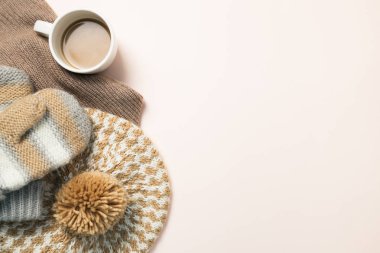 Kupa kahve ve sıcak örme şapka, eldiven pembe bir arka plan üzerinde. Kış sezon kavramı