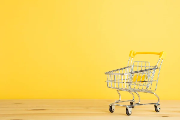 Carrito Compras Sobre Mesa Madera Con Fondo Amarillo — Foto de Stock