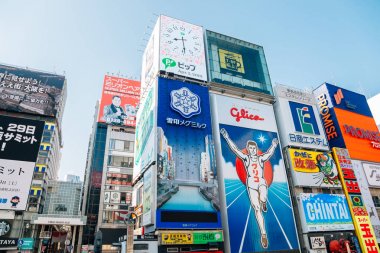 Osaka, Japonya - 3 Nisan 2019 : Dotonbori Glico çalışan adam işareti ve alışveriş caddesi