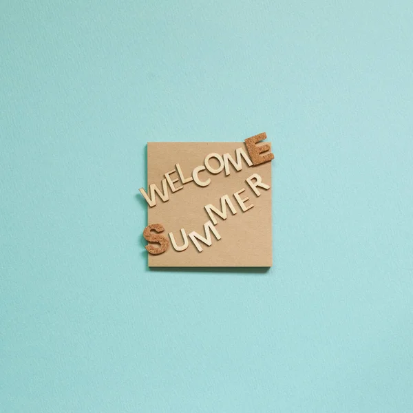 Word \'Welcome summer\' on memo pad on blue background. Summer vacation concept. top view