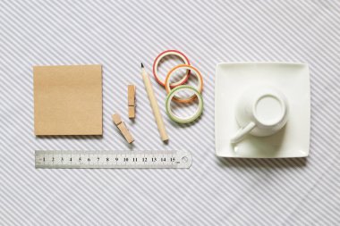 Not defteri, tahta tokalar, kalem, cetvel, bant, çizgili kumaş arka planda kahve fincanı. Çalışma ve öğrenim yeri. düz alan, üst görünüm, kopyala boşluk