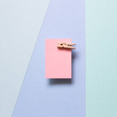 Pembe not kağıdı, mavi arka planda tahta raptiyesi olan yapışkan notlar. Üst görünüm, boşluk kopyala