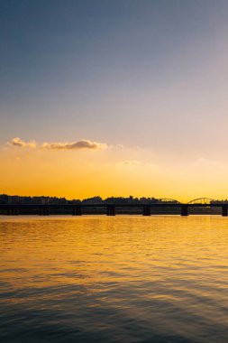 Dongjak Köprüsü ve modern şehir manzarası Seul, Kore 'deki Banpo Hangang Parkı' ndan dramatik günbatımı gökyüzü altında Han Nehri ile birlikte.