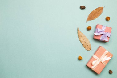 Yeşil arka planda sonbahar kuru yaprakları olan hediye kutuları. düz alan, üst görünüm, kopyala boşluk
