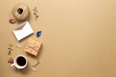 Hediye kutusu, kart ve koyu kahve. Kahverengi kraft kağıdında kuru bitki var. düz alan, üst görünüm, kopyala boşluk