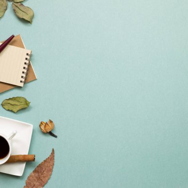 Sonbahar konsepti. Yeşil arka planda kuru yapraklı defter ve sade kahve. Düz konum, üst görünüm, kopyalama alanı. Çalışma ve öğrenim yeri