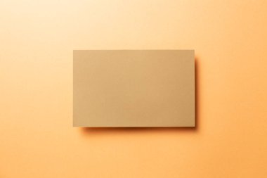 Kraft kahverengi not defteri, turuncu arka planda boş kağıt. Üst görünüm, boşluk kopyala