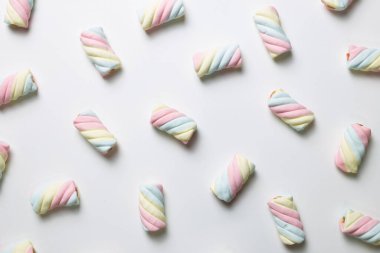 Beyaz arka planda renkli marşmelov. Düz yatış, üst manzara. Lezzetli abur cubur şablonu