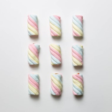 Beyaz arka planda renkli marşmelov. Düz yatış, üst manzara. Lezzetli abur cubur şablonu