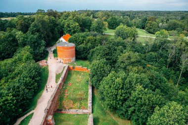 Turaida Kalesi 'nin panoramik manzarası Sigulda, Letonya' daki yeşil ormanlarla harabeye döndü