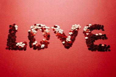 Beautiful inscription of red sequins in the form of hearts for Valentine's Day or for the wedding. The inscription 