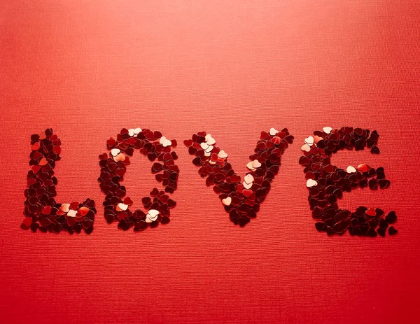 Beautiful inscription of red sequins in the form of hearts for Valentine's Day or for the wedding. The inscription 