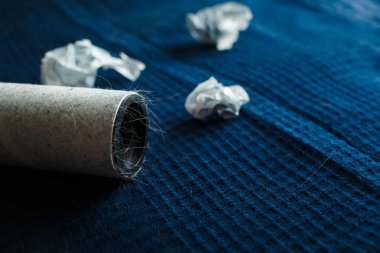 Karanlık bir ekose ve bir silindir yapışkan bant ile yün elbise temizliği için hafif yün sıkışmış.