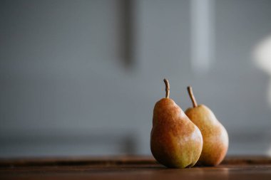 Işıklar bir çelenk ile büyük bir mutfak ahşap masada güzel olgun lezzetli armut. Sağlıklı gıda hakkında bir makale için güzel bir ekran koruyucu, bir gıda blogu için bir kavram, bir pasta şefi için bir koruyucu