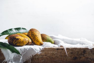 Doğa mango beyaz kumaş ve ahşap plaka üzerinde 