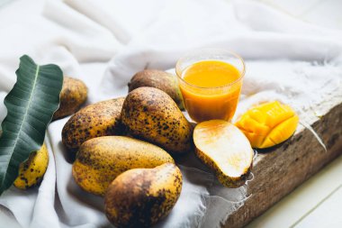 doğa mango ve mango suyu ahşap bir masa ve bir beyaz bez