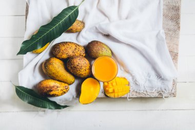 doğa mango ve mango suyu ahşap bir masa ve bir beyaz bez
