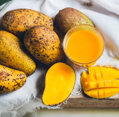 doğa mango ve mango suyu ahşap bir masa ve bir beyaz bez