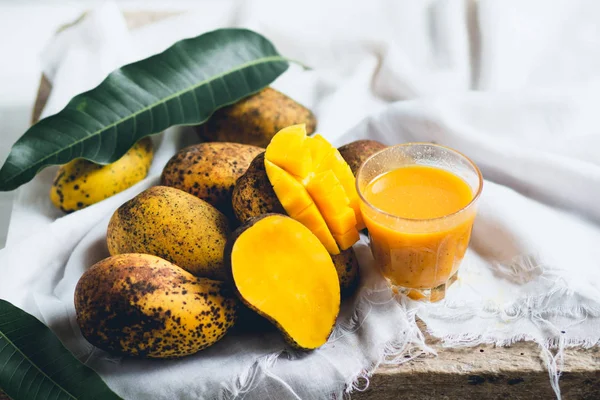 doğa mango ve mango suyu ahşap bir masa ve bir beyaz bez