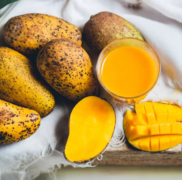 doğa mango ve mango suyu ahşap bir masa ve bir beyaz bez