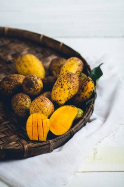 Sepeti ahşap bir masa ve bir beyaz bez harman içinde doğa mango