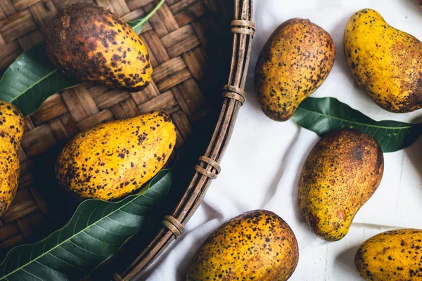 Sepeti ahşap bir masa ve bir beyaz bez harman içinde doğa mango