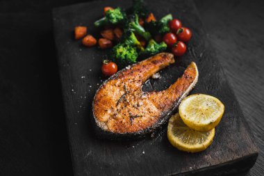 Somon steak ve sebze siyah ahşap doğrama 