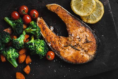 Somon steak ve sebze siyah ahşap doğrama 