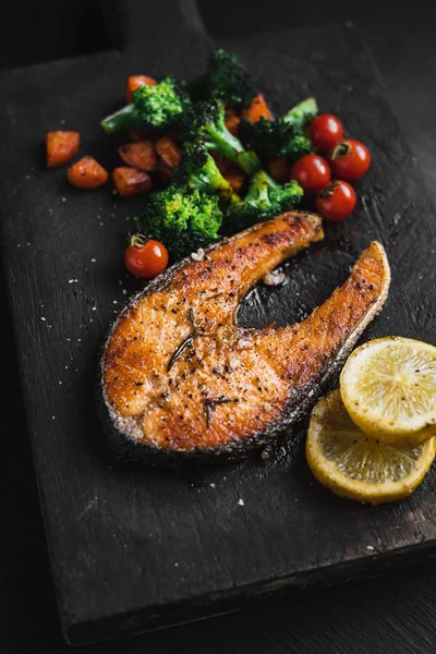 Somon steak ve sebze siyah ahşap doğrama 