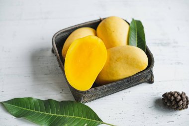Beyaz ahşap arka plan üzerinde sepette Mango