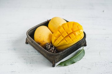 Beyaz ahşap arka plan üzerinde sepette Mango