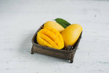 Beyaz ahşap arka plan üzerinde sepette Mango