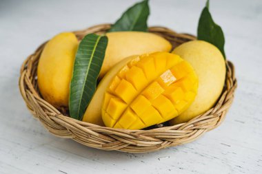 Beyaz ahşap arka plan üzerinde sepette Mango