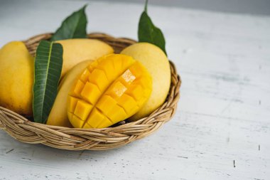 Beyaz ahşap arka plan üzerinde sepette Mango