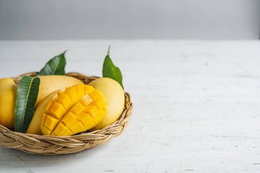 Beyaz ahşap arka plan üzerinde sepette Mango